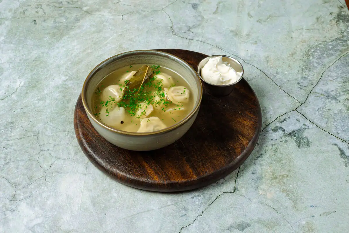 Пельмени с бульоном и сметаной