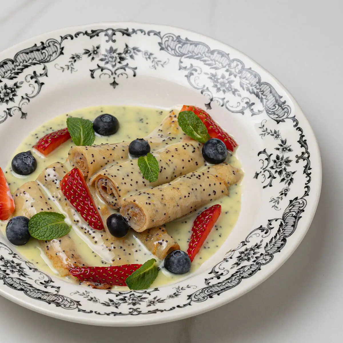 Блины маковые с горячим соусом и ягодами