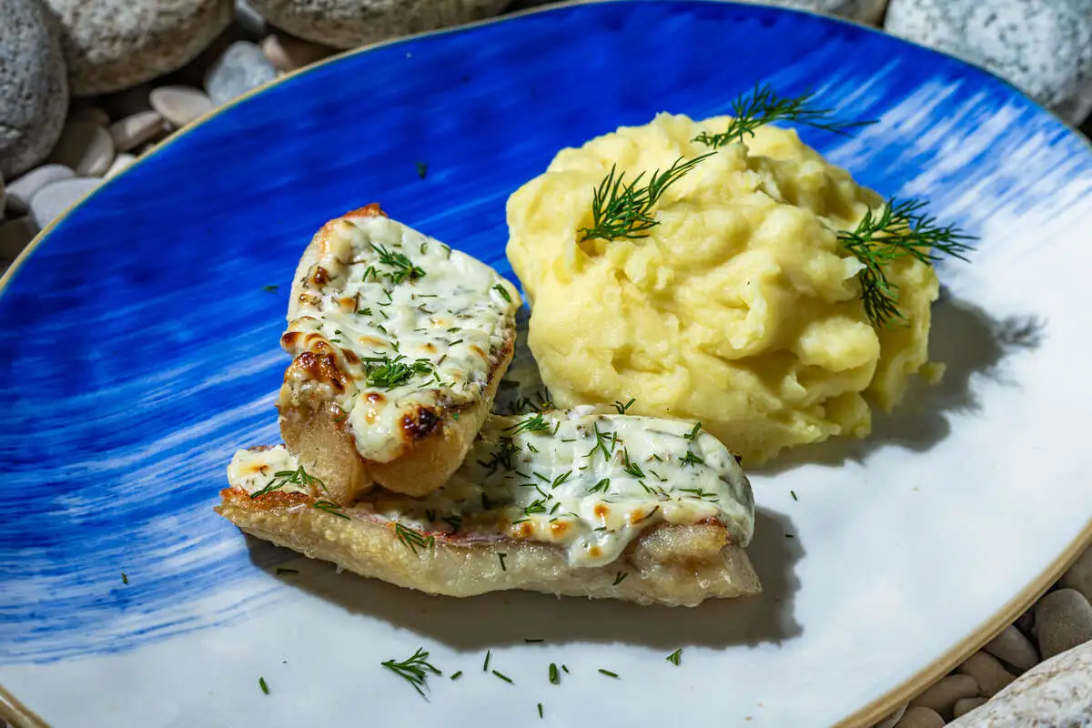 Окунь в сметане с чесноком и зеленью, подается с картофельным пюре