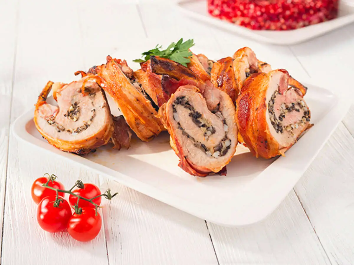 Фаршированная шампиньонами свиная корейка, запечённая в беконе