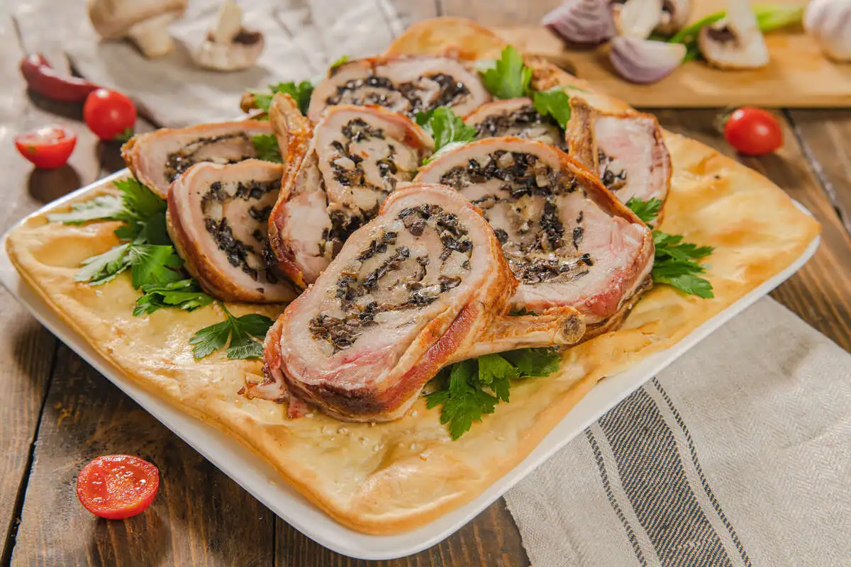 Фаршированная шампиньонами свиная корейка, запечённая в беконе