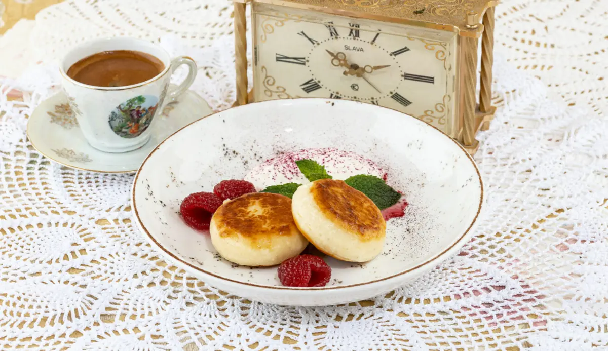 Домашние сырники со сметаной и малиновой пудрой