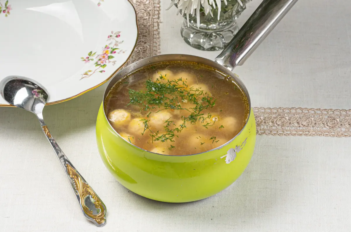 Бульон с куриными фрикадельками, домашней лапшой и перепелиным яйцом, с зеленью