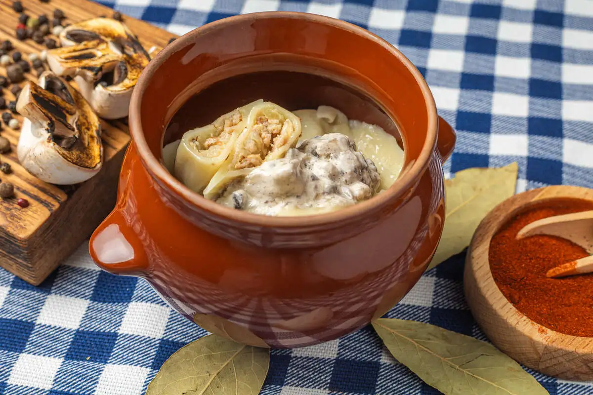 Вареники с капустой, жареной курицей и грибным соусом