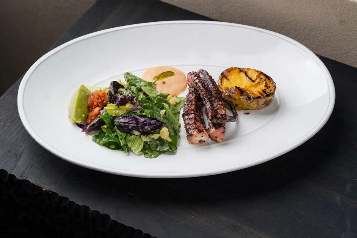 Осьминог с печеным на углях картофелем и соусом Ромеско