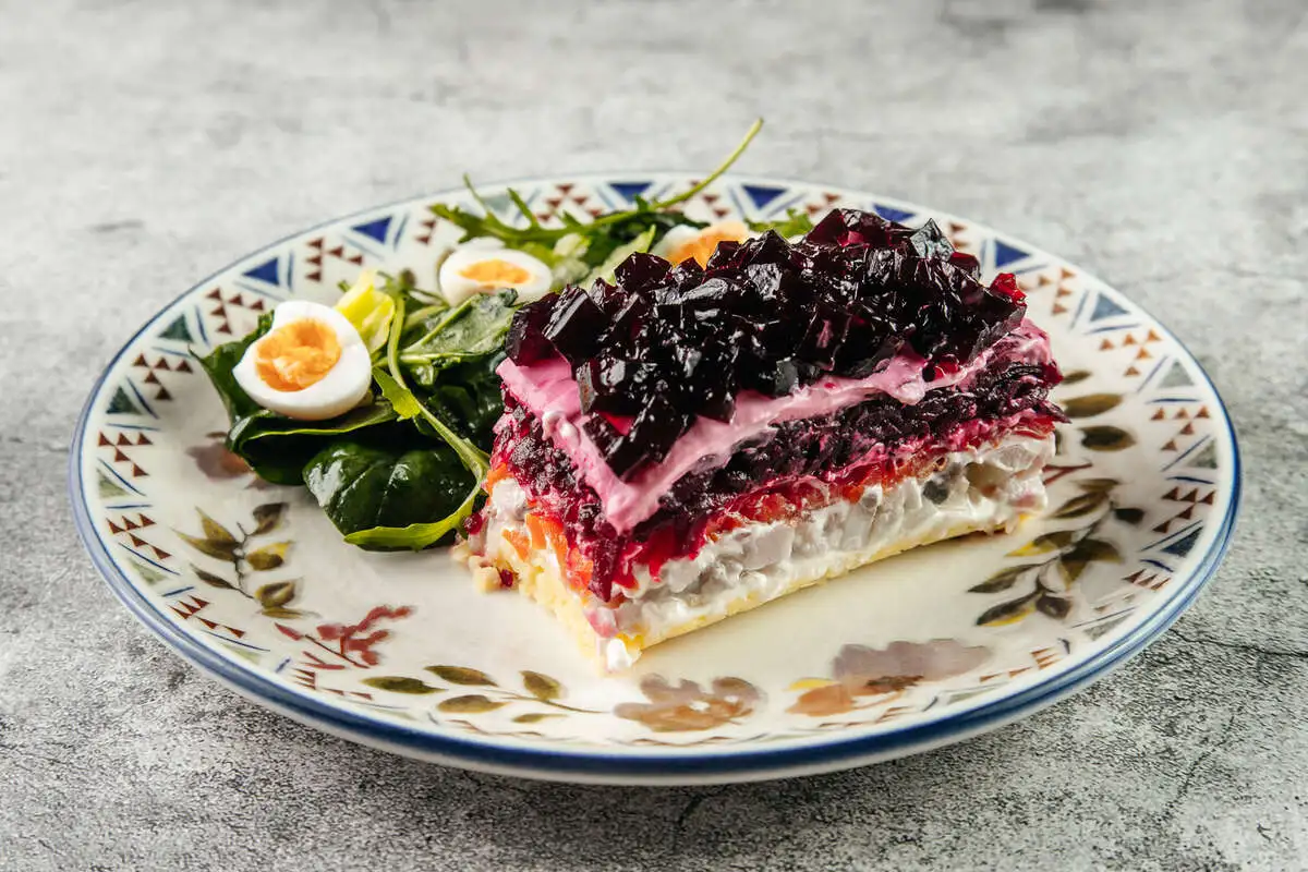 Сельдь под шубой с листьями салата и перепелиными яйцами