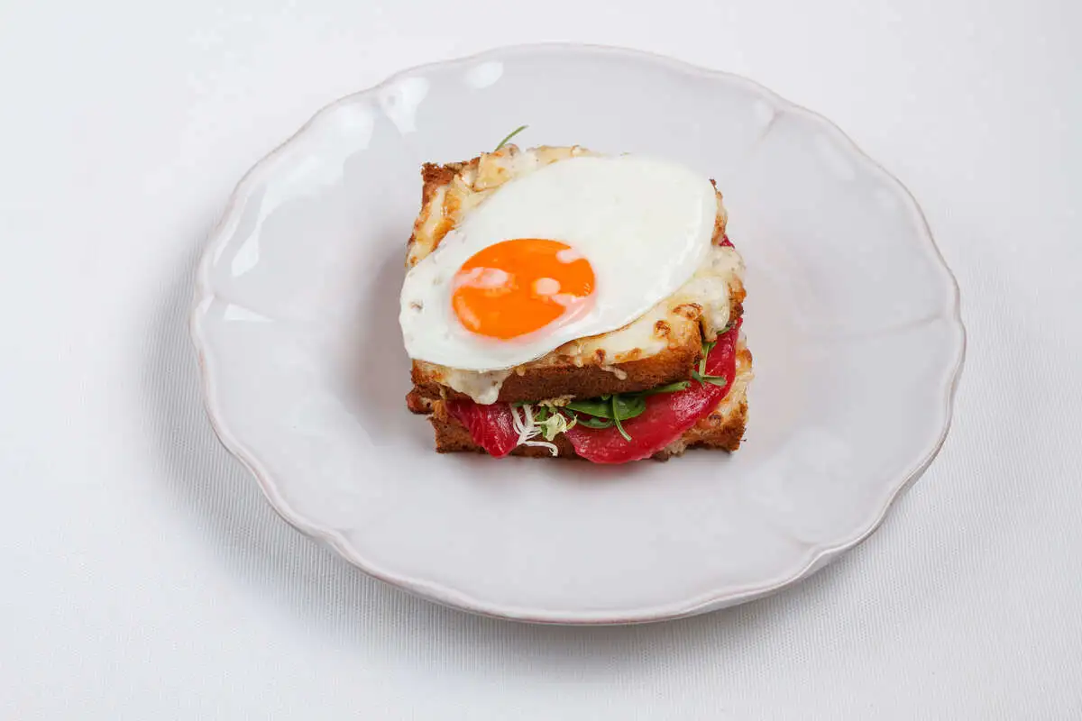 Крок мадам с лососем, салатом, сыром и яйцом