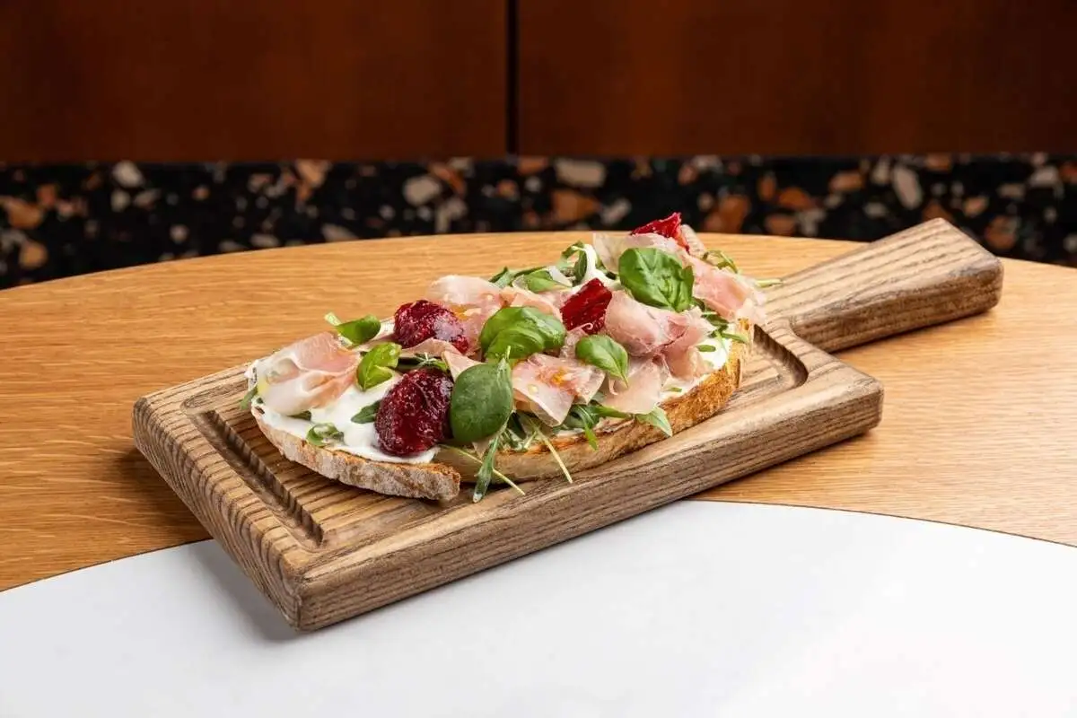 Брускетта с пармской ветчиной, страчателлой и красным апельсином