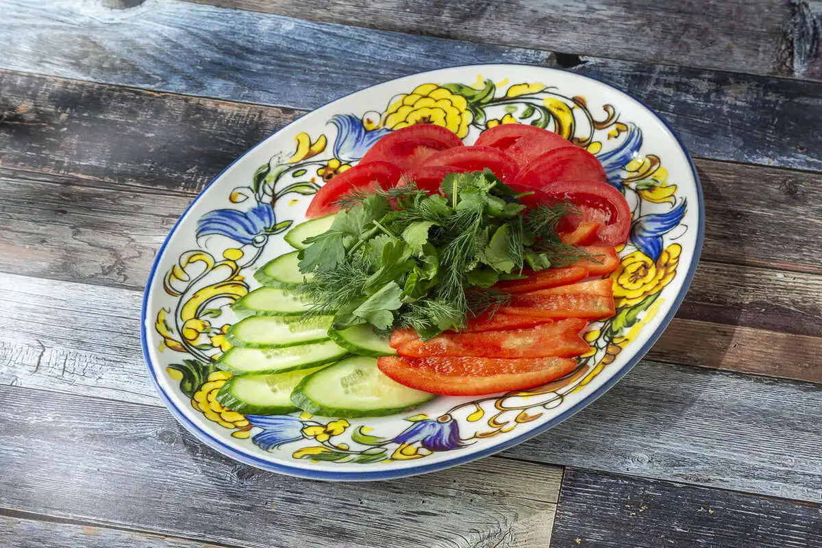 Тарелка со свежими овощами и зеленью