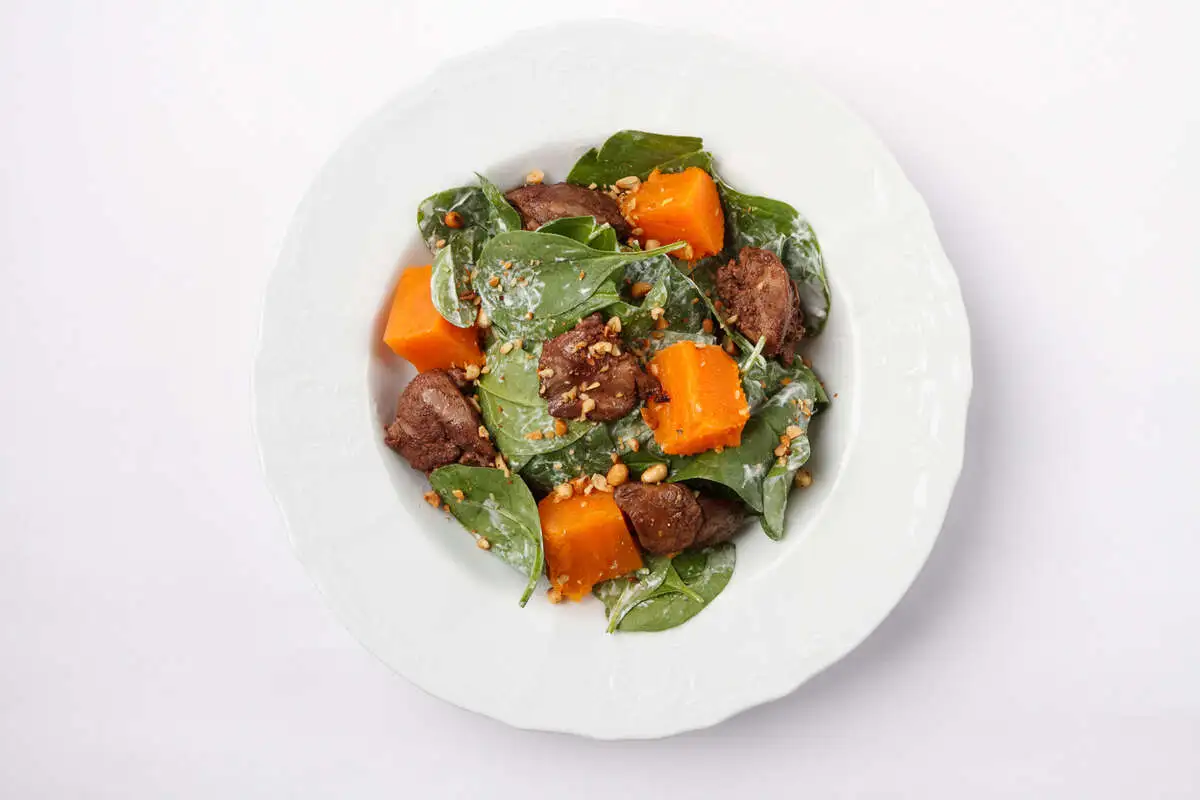 Шпинат с куриной печенью, бататом и жареными орешками пиноли