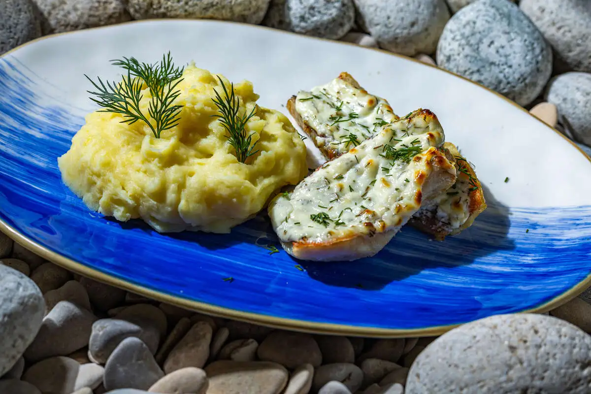 Окунь в сметане с чесноком и зеленью, подается с картофельным пюре
