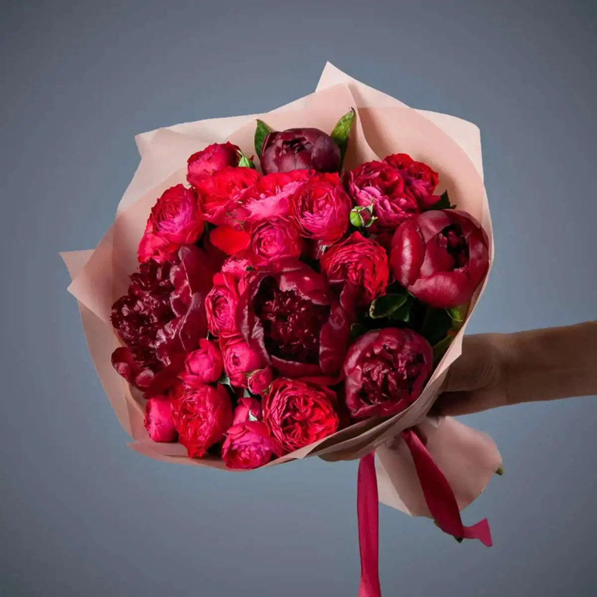 Букет из 5 пионов Red charm и роз в розовой упаковке